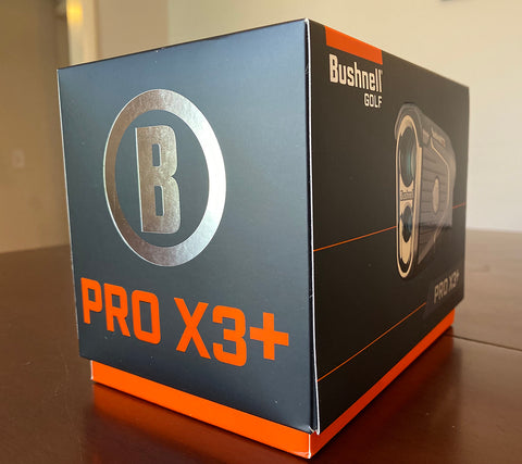 The Bushnell Pro X3+ in it's box on a table before Marc opens it