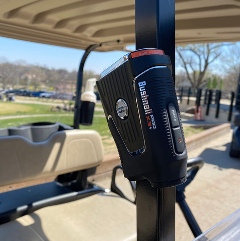 The Bushnell Pro X3+ attached by the magnet to a golf cart pole at the golf course with our reviewer Marc