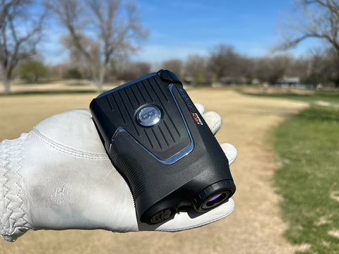 The Bushnell Pro X3+ in Marc's white, golf-gloved hand on the golf course