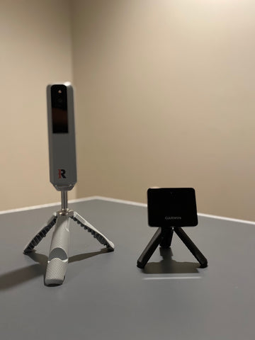 Both the Rapsodo MLM2PRO and Garmin Approach R10 set up on their tripods indoors
