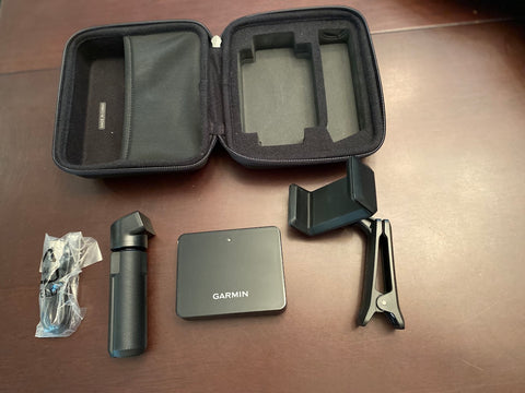 An unpacked Garmin Approach R10 with open case, R10 unit, tripod, cable, and phone clip spread on a desk