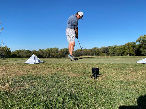 PlayBetter golf reviewer, Marc, preparing to swing with a Garmin Approach R10 set up behind him at the golf range