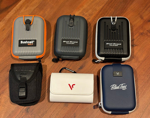 Six golf rangefinder cases laying on a table