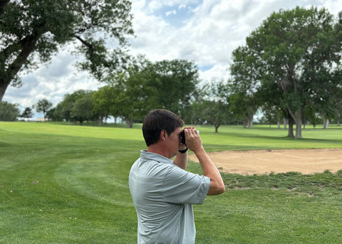 PlayBetter golf reviewer Marc with the Garmin Approach Z30 rangefinder viewfinder to his eye on the golf course