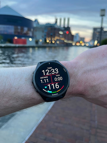 The Garmin Forerunner 965 on a wrist with downtown Baltimore in the background