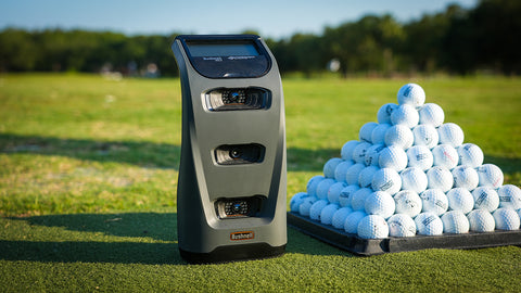 Bushnell Launch Pro at the golf range with a pyramid of golf balls
