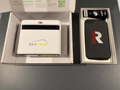 SkyTrak+ and Rapsodo MLM2PRO next to each other in their open product boxes