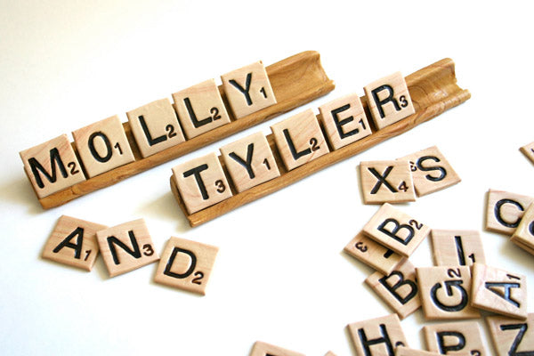 Scrabble tiles spell out a bride and grooms names as a creative photograph for their wedding photo album