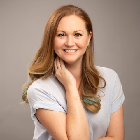 a portrait of a smiling women with long red hair