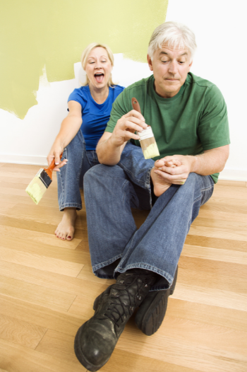 man painting woman's toenails with a house painting brush