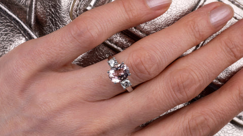 woman's hand wearing morganite ring clutching bag