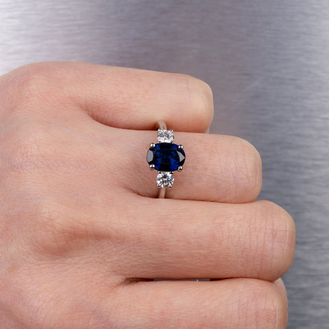 woman wearing blue sapphire diamond three stone ring