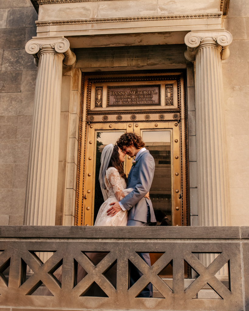 bride and groom standing on balcony 