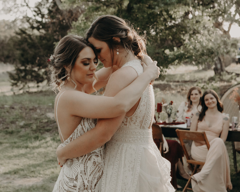 Brides embracing during first dance. 