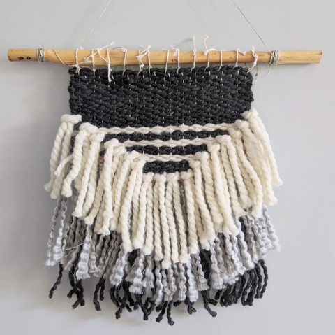 Woven wall tapestry with black and white stripes and tassels