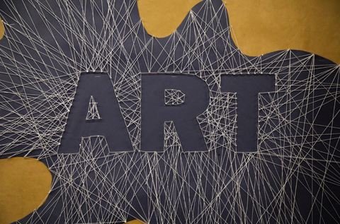 A black and yellow background with white string on top outlining the word "ART" in the center.