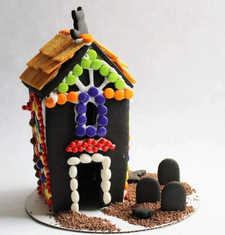 A gingerbread house made out of black gingerbread with bright candies