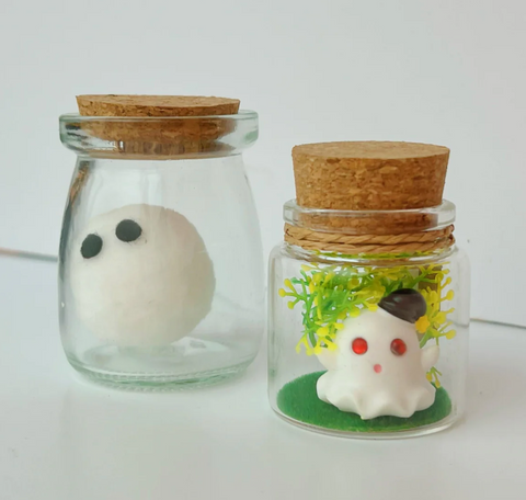 Two bottles with cotton or resin ghost figures inside