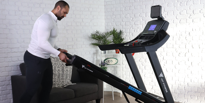 Man folding a foldable Treadmill