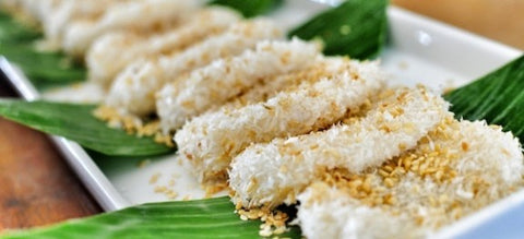 A close up photo of a set of Palitaw laid on top of banana leaves and white plate.