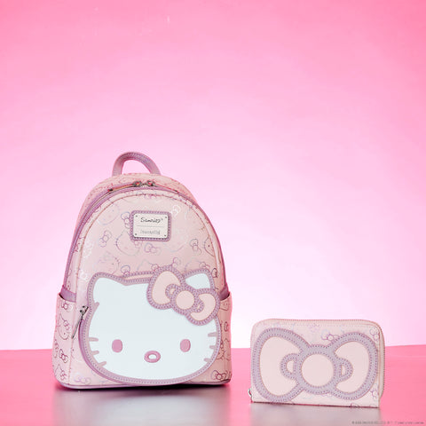 Pink iridescent mini backpack with Hello Kitty on the front pocket and pink iridescent wallet with Hello Kitty's bow on the front.