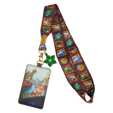 Land Before Time lanyard and cardholder featuring the Cera, Little Foot, Petrie, Spike, and Ducky walking along a log with Sharptooth in the background. The lanyard shows portraits of each of the dinosaurs. Includes a tree star keychain.