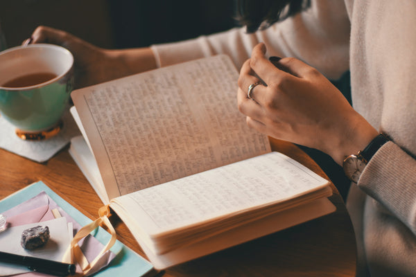 writing in a journal with coffee