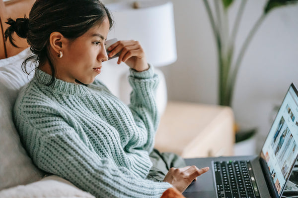 woman looking at computer sitting on couch