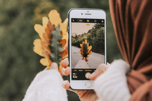 woman taking a photo of a leaf