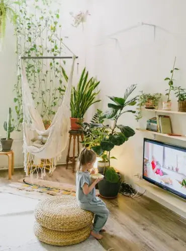 a child is eating breakfast in the living room arounded by plants-inselife.com