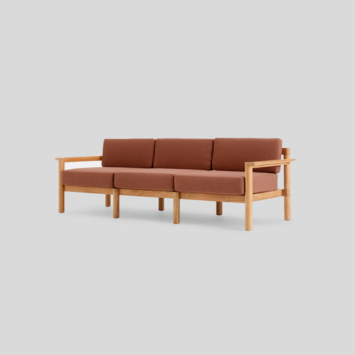 A studio photo of Haven Sofa Sunbrella Rust / Teak Armrest