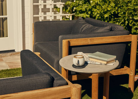 Cozy outdoor chair with cushions and rounded concrete side table
