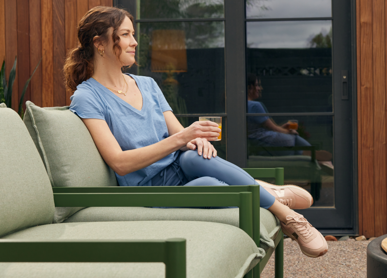 woman drinking juice on sofa