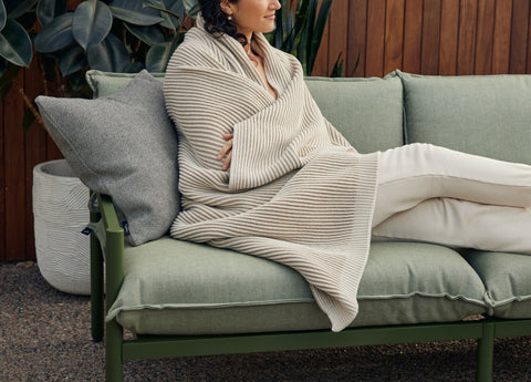 Women wrapped in blanket on outdoor sofa