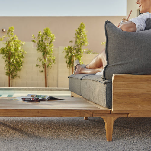 A studio photo of Bluff Sofa with In-line Table Sunbrella Graphite