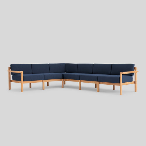 A studio photo of Haven Sectional Sunbrella Indigo / Six Piece / Teak Armrest