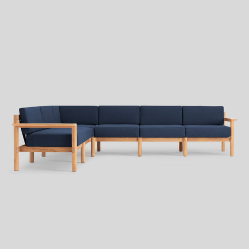 A studio photo of Haven Sectional Sunbrella Indigo / Six Piece / Teak Armrest