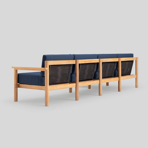 A studio photo of Haven Sectional Sunbrella Indigo / Six Piece / Teak Armrest