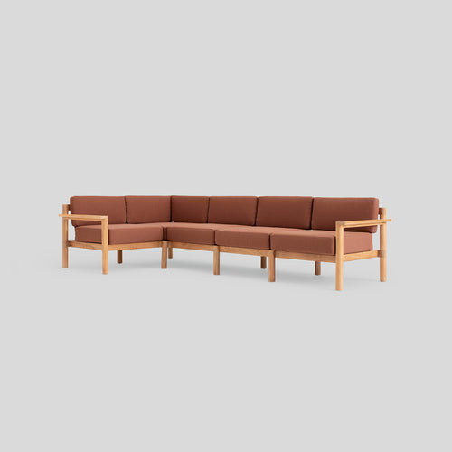 A studio photo of Haven Sectional Sunbrella Rust / Five Piece / Teak Armrest