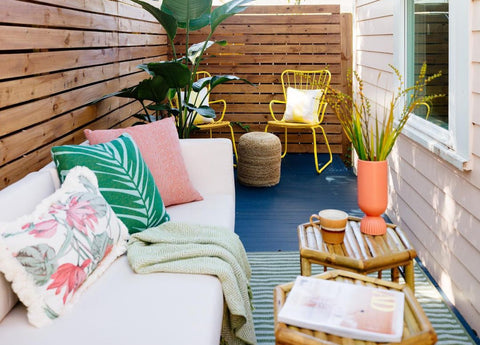 Colorful outdoor nook with bright pillows and chairs