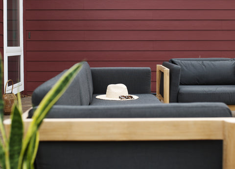 Dark gray-colored sectional against a red exterior wall