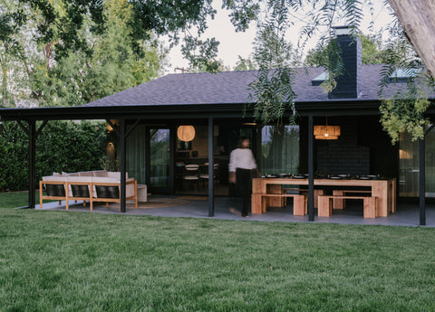 Dark painted exterior of modern home with outdoor furniture featured under covered porch