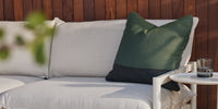 Two plush Neighbors Throw Pillows resting on a Neighbor outdoor teak sectional