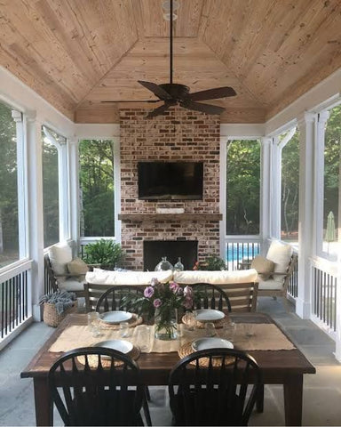 Rustic screened in porch with brick fireplace