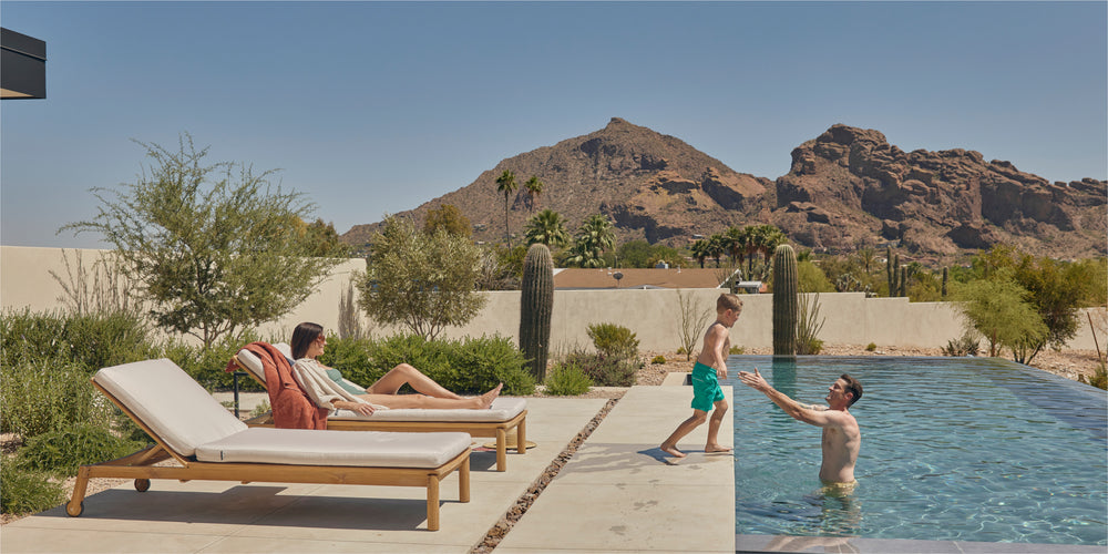 A young family enjoying time by the pool on a set of Neighbor sun loungers