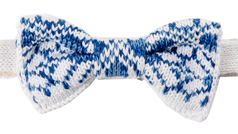 A white knitted bow tie with blue delftware pottery style pattern