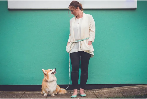 A white french woman looks down at her corgi, Marcel