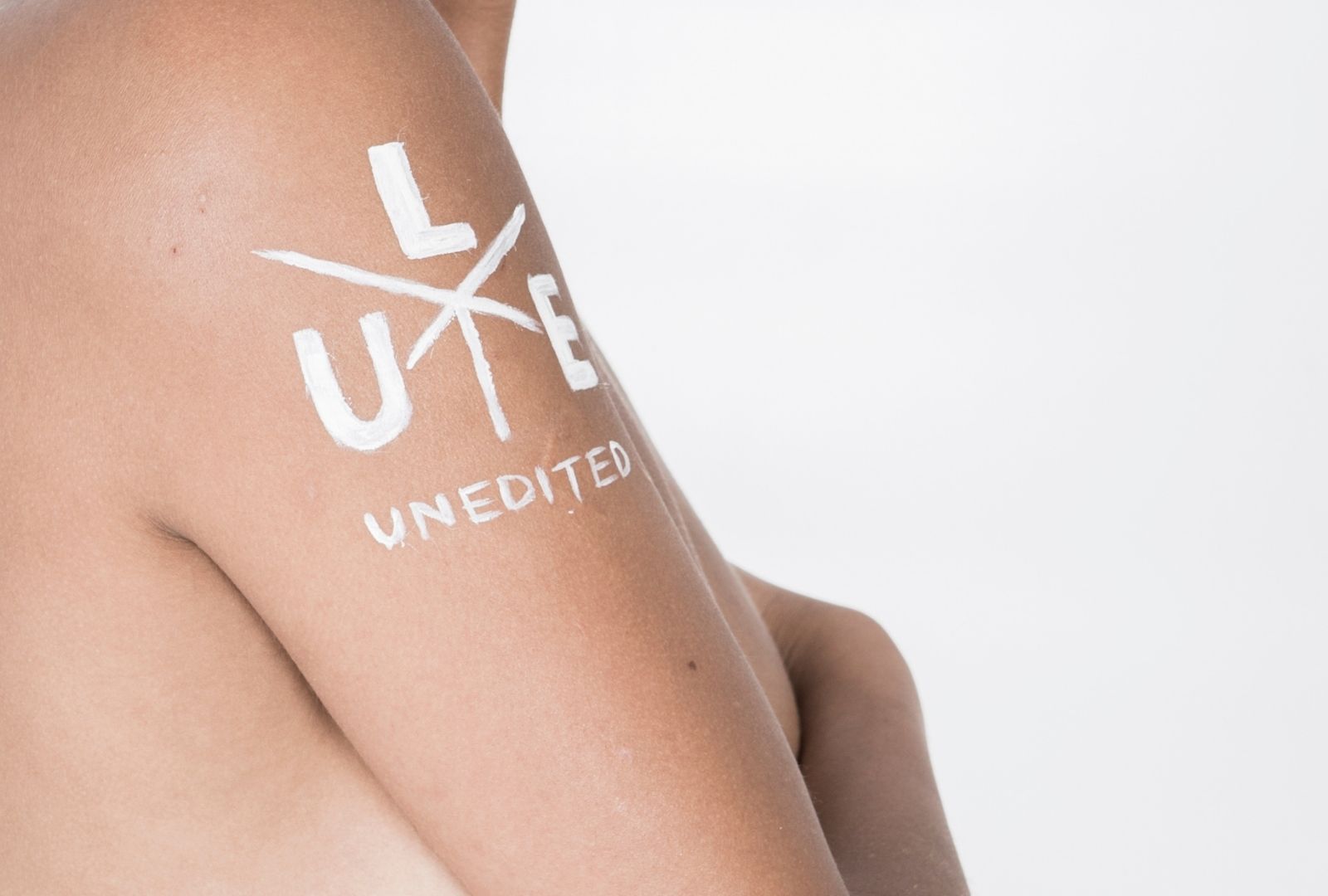 Bare arm with Unedited logo written on it