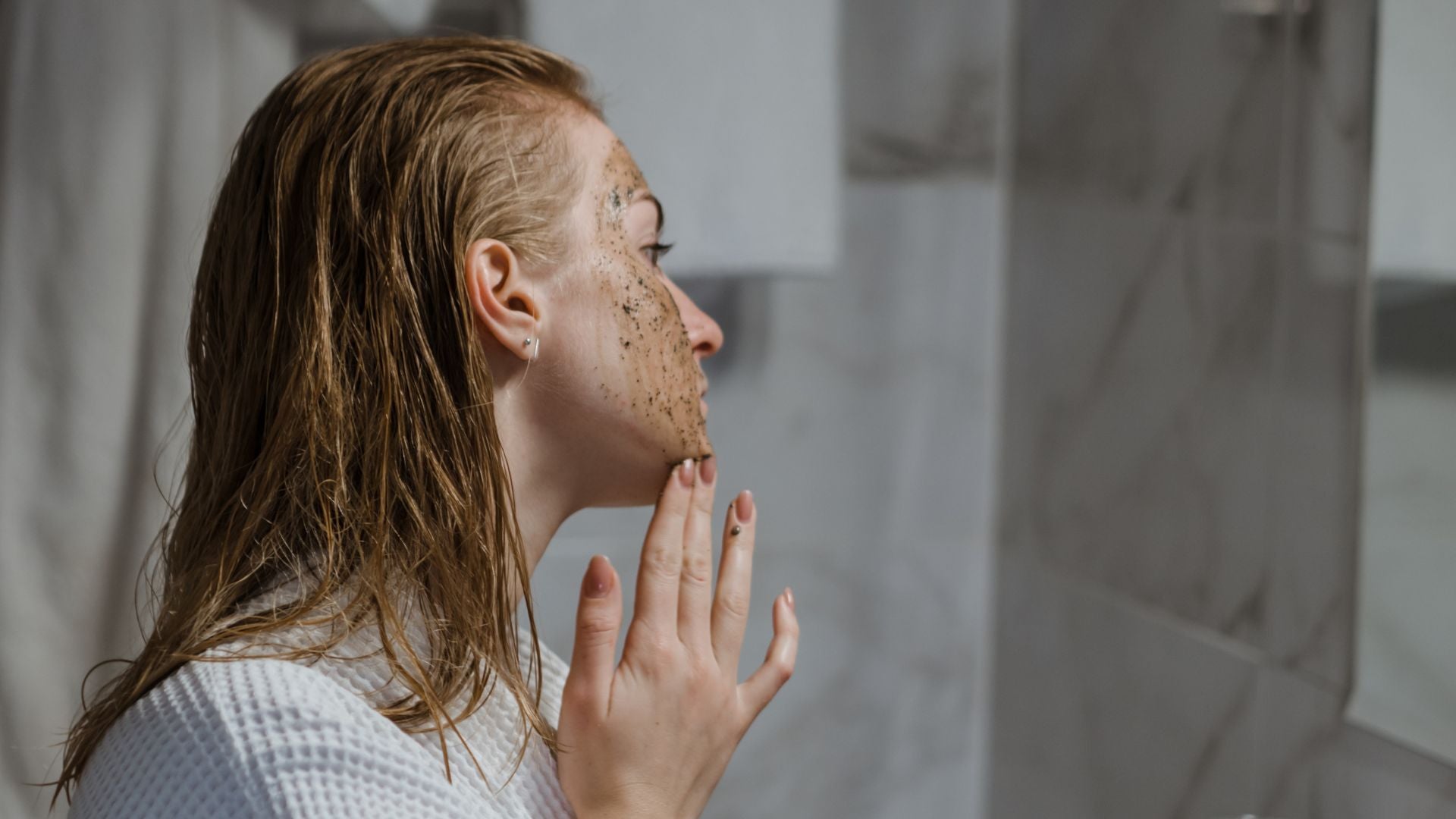 Woman using a coffee scrub on her face