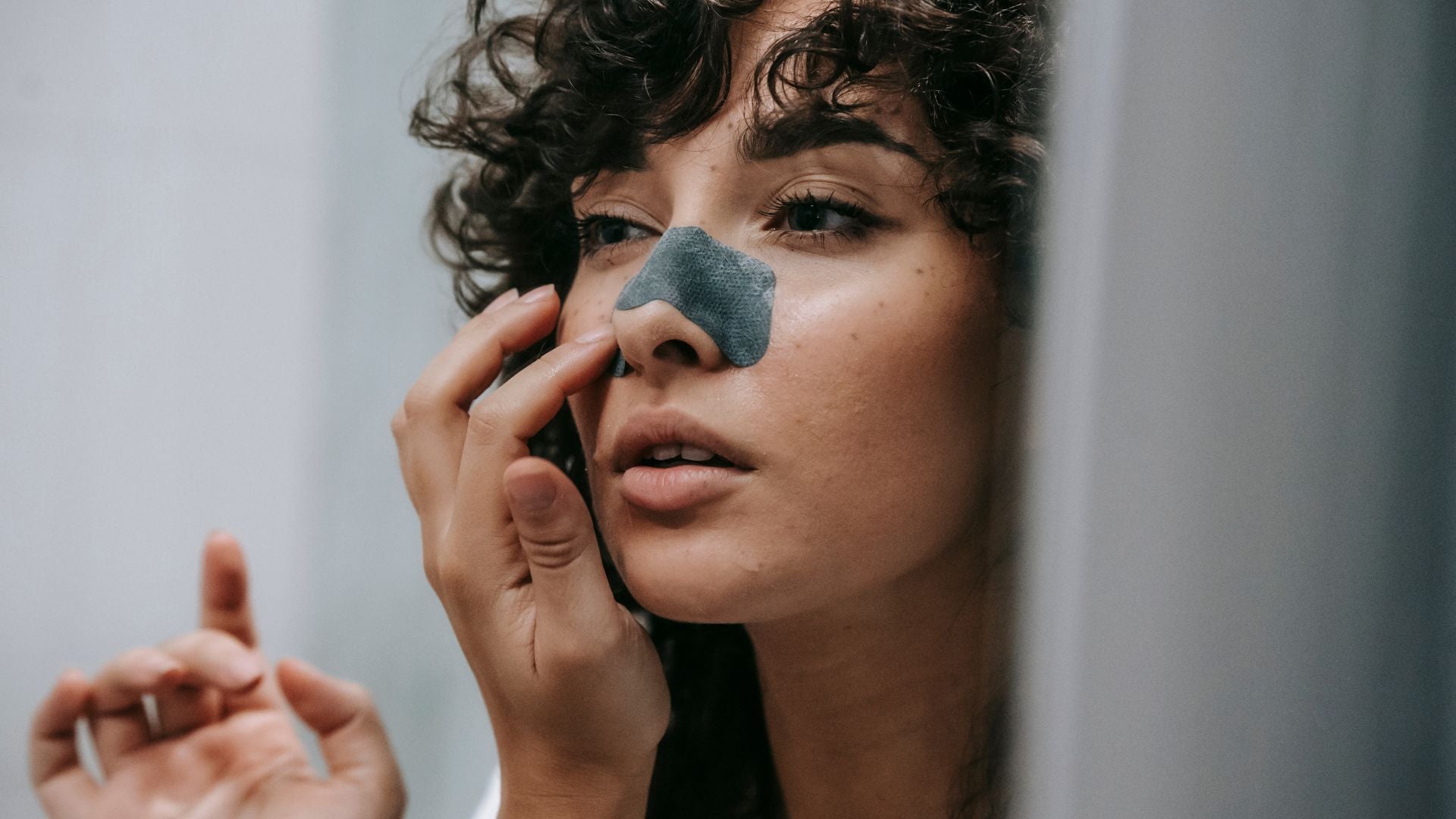 Woman using a charcoal nose strip